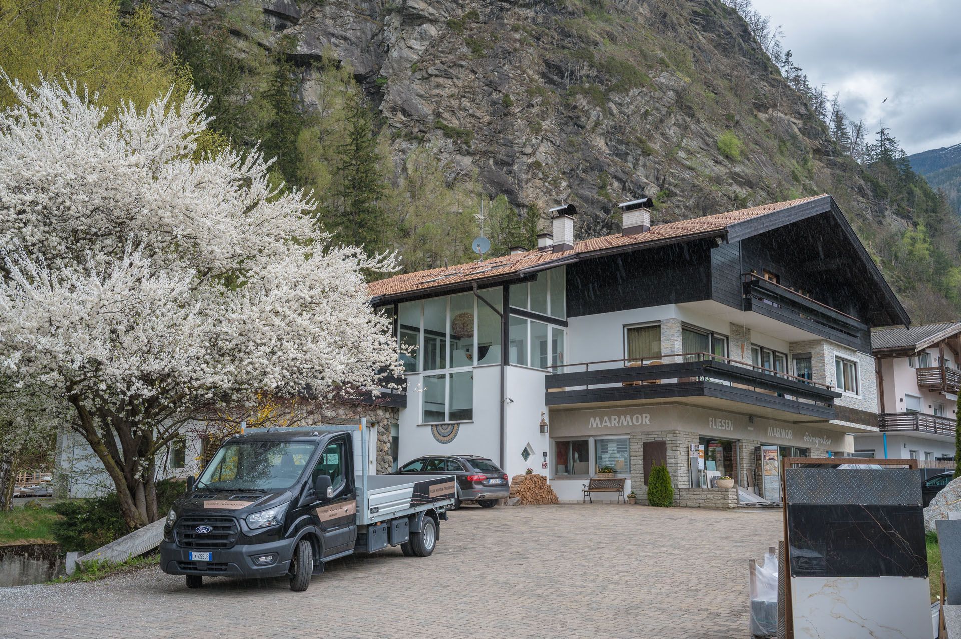 Vor einem großen Haus parkt ein Lieferwagen von Fliesen-Leimgruber in Sand in Taufers..