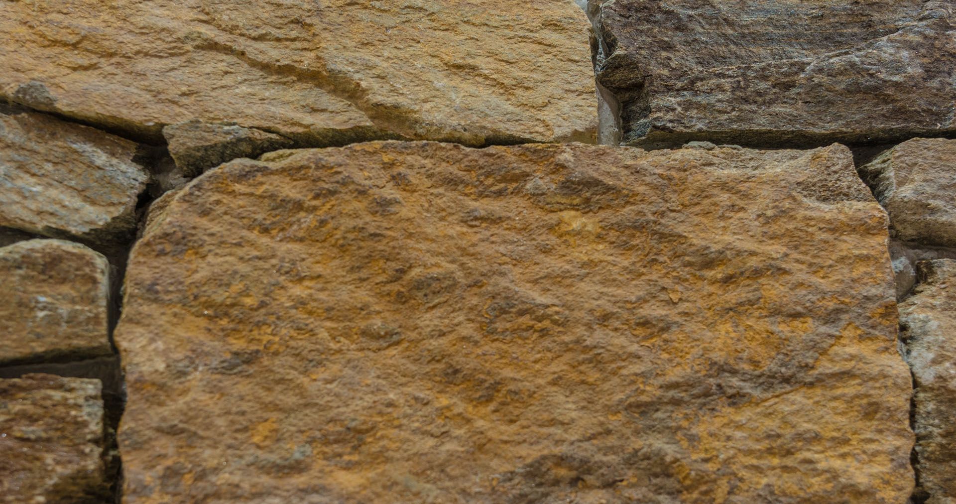Eine Nahaufnahme einer Steinmauer mit vielen verschiedenen Gesteinsarten.