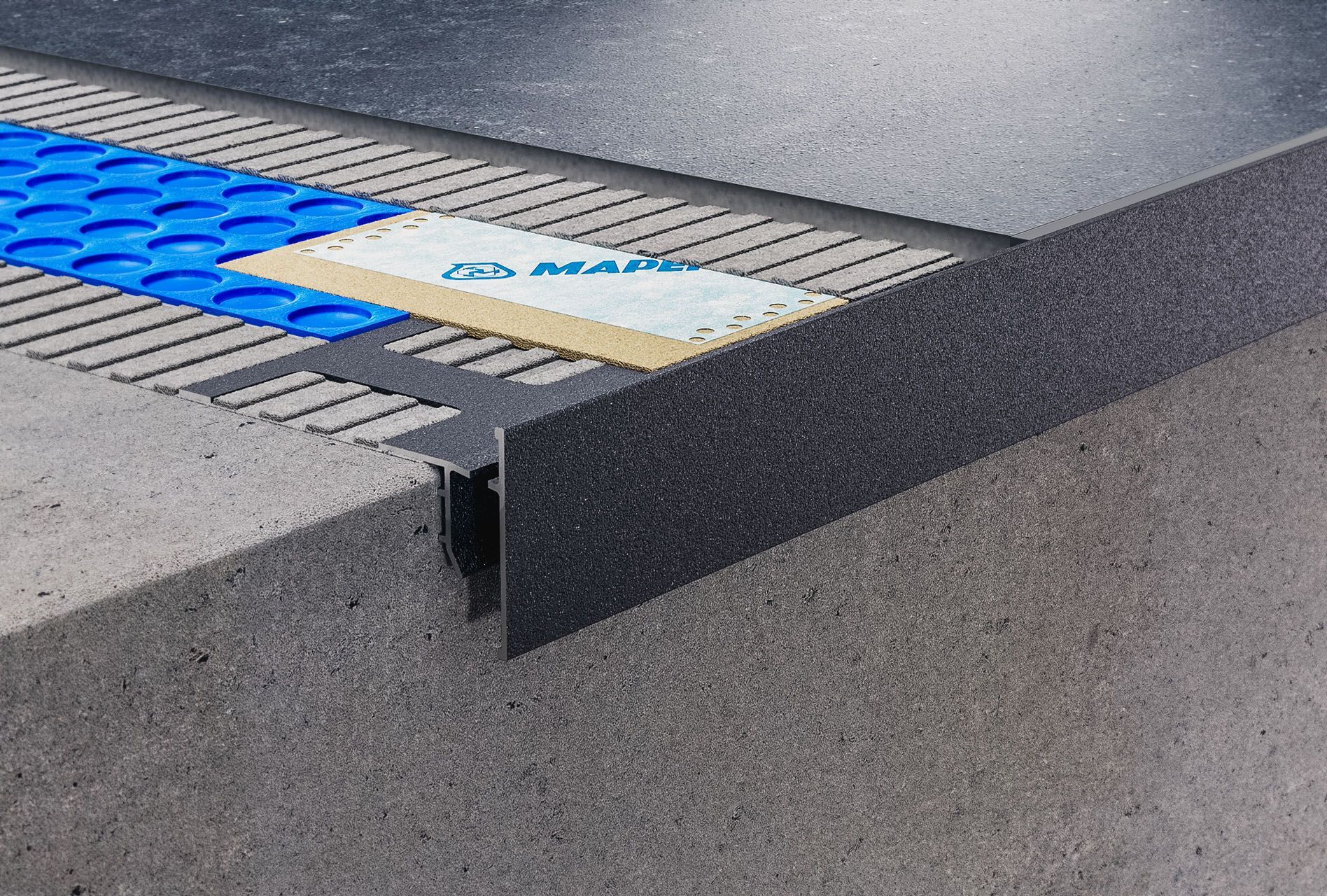 Eine Nahaufnahme eines Betonbodens mit blauen Fliesen darauf.