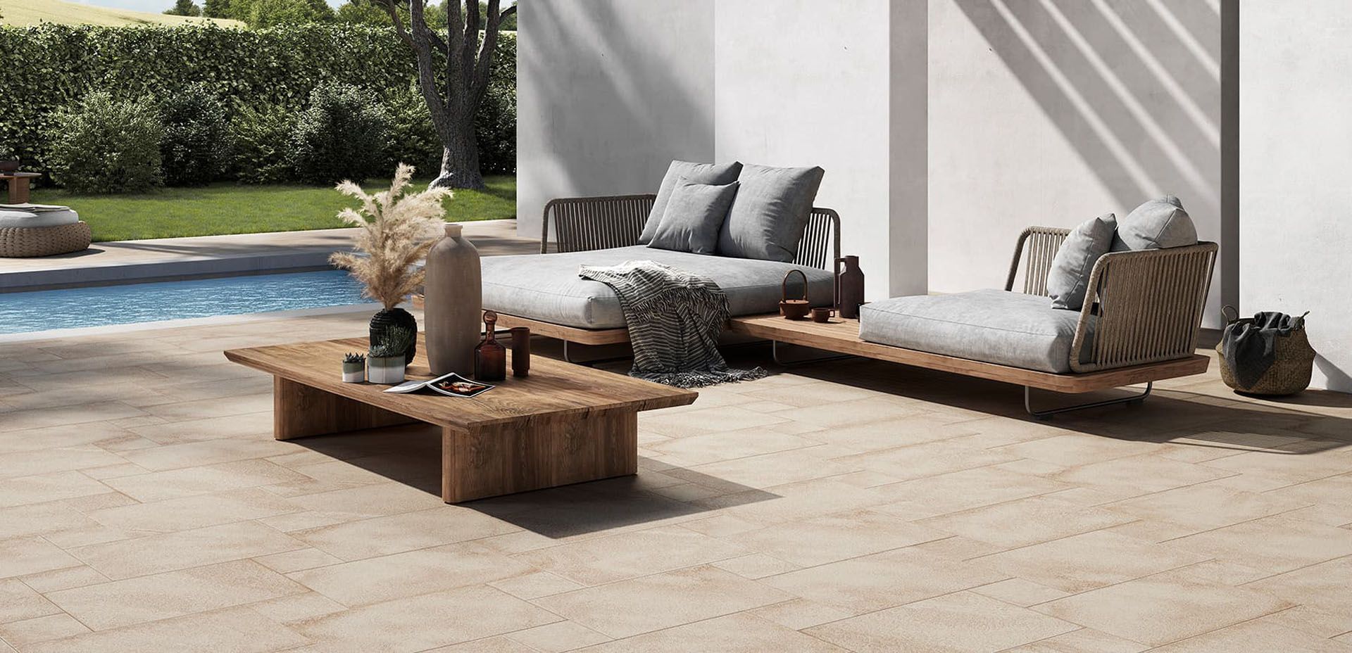 Eine gefliestes Terrasse mit einem Sofa und einem Couchtisch neben einem Pool.