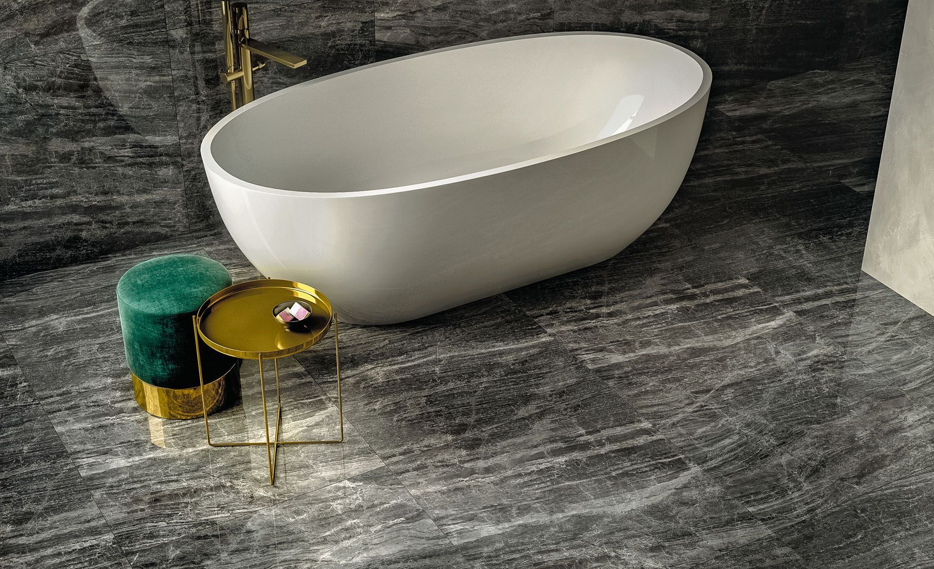 Ein Badezimmer mit schwarzen Fliesen, Badewanne und Waschbecken auf dem Boden.