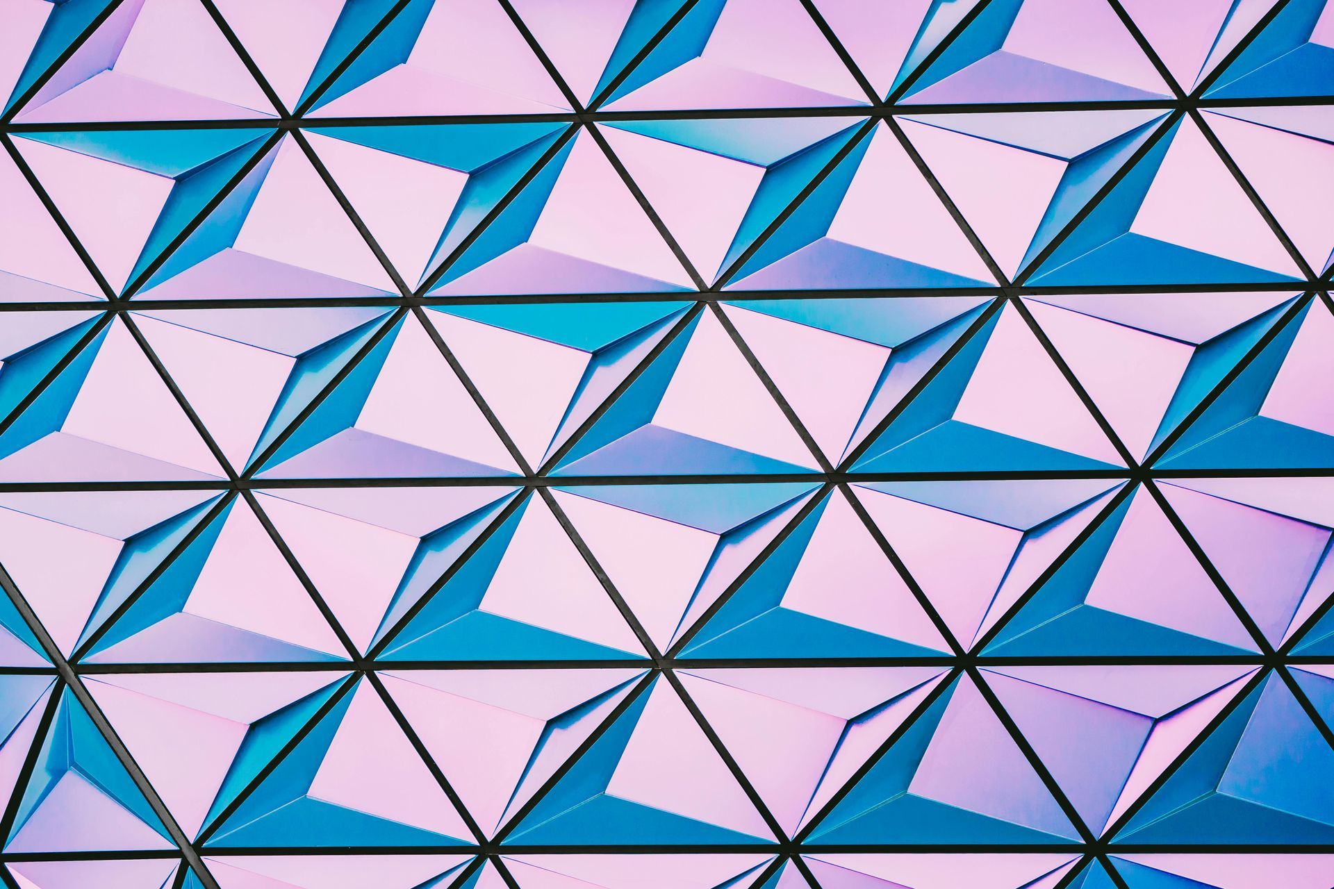 Eine Nahaufnahme eines blau-rosa geometrischen Musters an einer Wand.