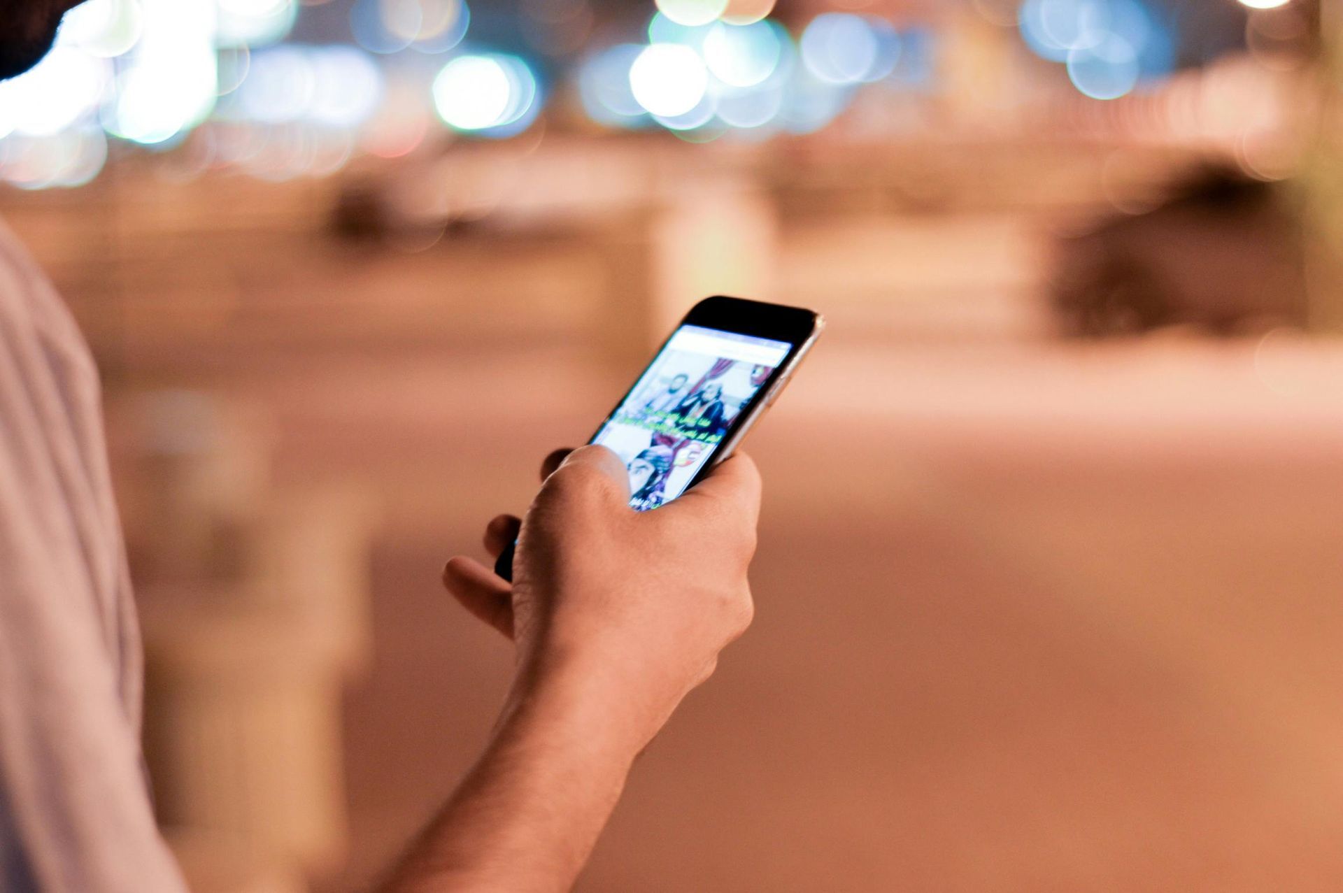 Eine Person hält ein Mobiltelefon in der Hand.