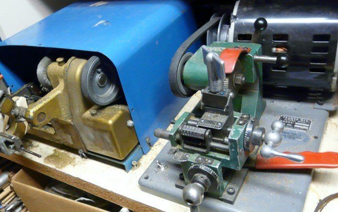 Key-cutting machine with blue and green components, and a black motor, used for copying keys.