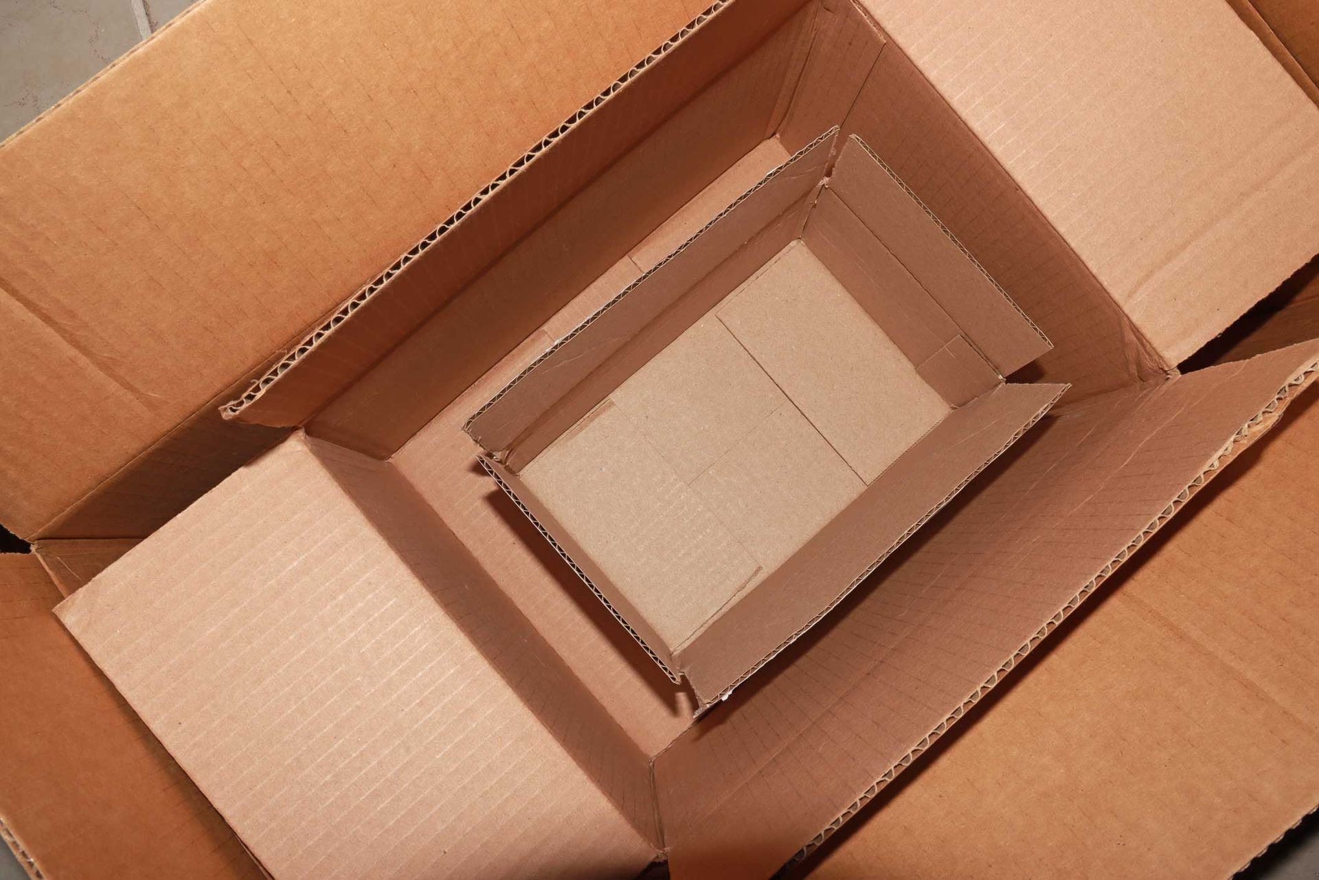 Empty cardboard boxes inside a box viewed directly above.