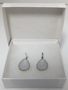 Pair of teardrop-shaped light blue earrings in a white gift box.