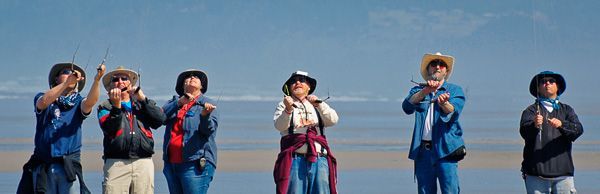 A group of people are standing next to each other on a beach.