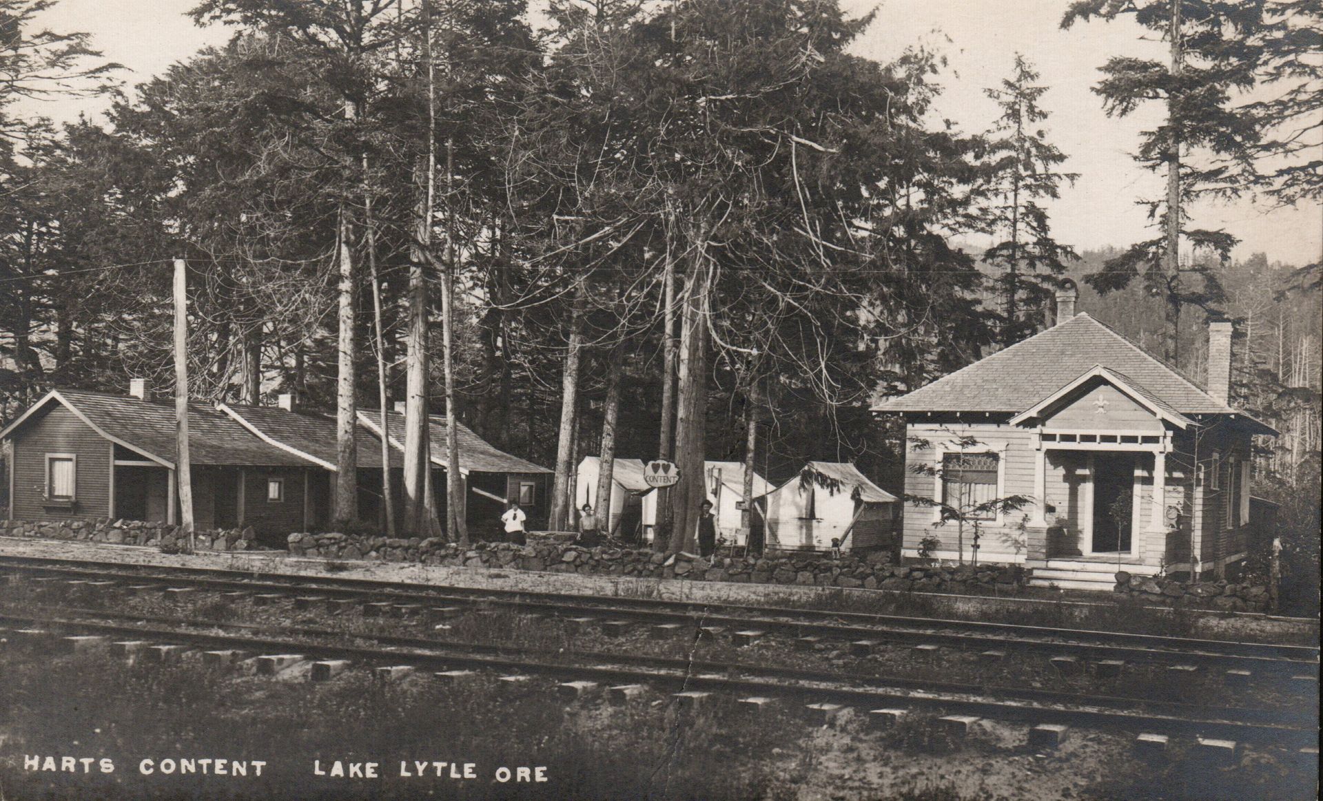 Hart's Content, Oregon: buildings and railroad tracks in a wooded setting.