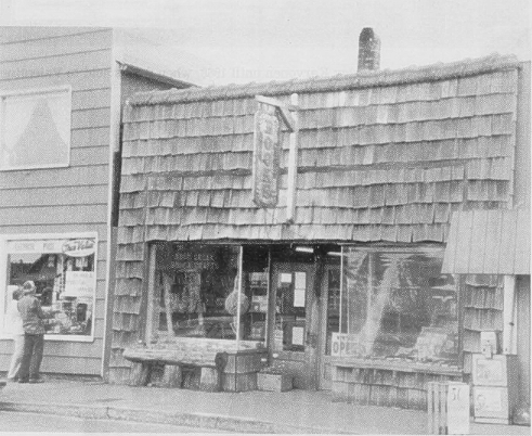Old sepia-toned church with steeple, small porch, and shed. Text on image: 
