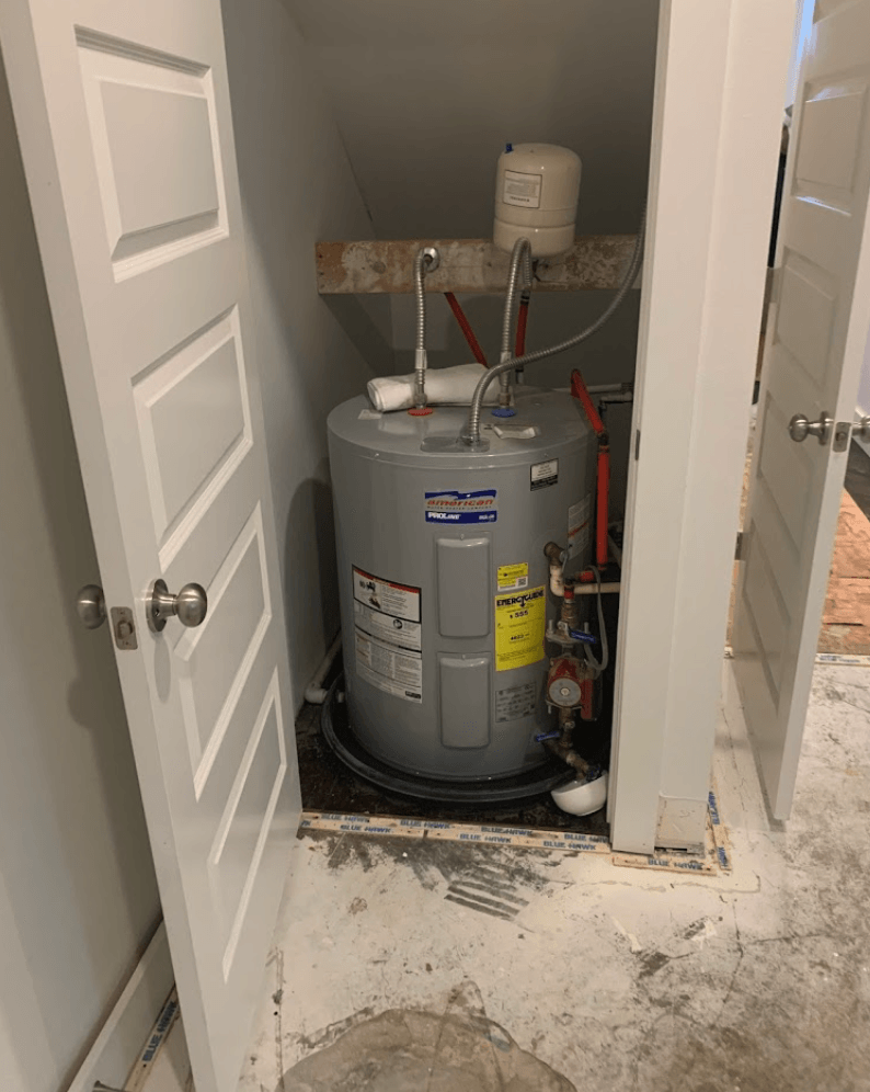 A water heater busted inside a closet with white doors.  Broken pipe caused water damage