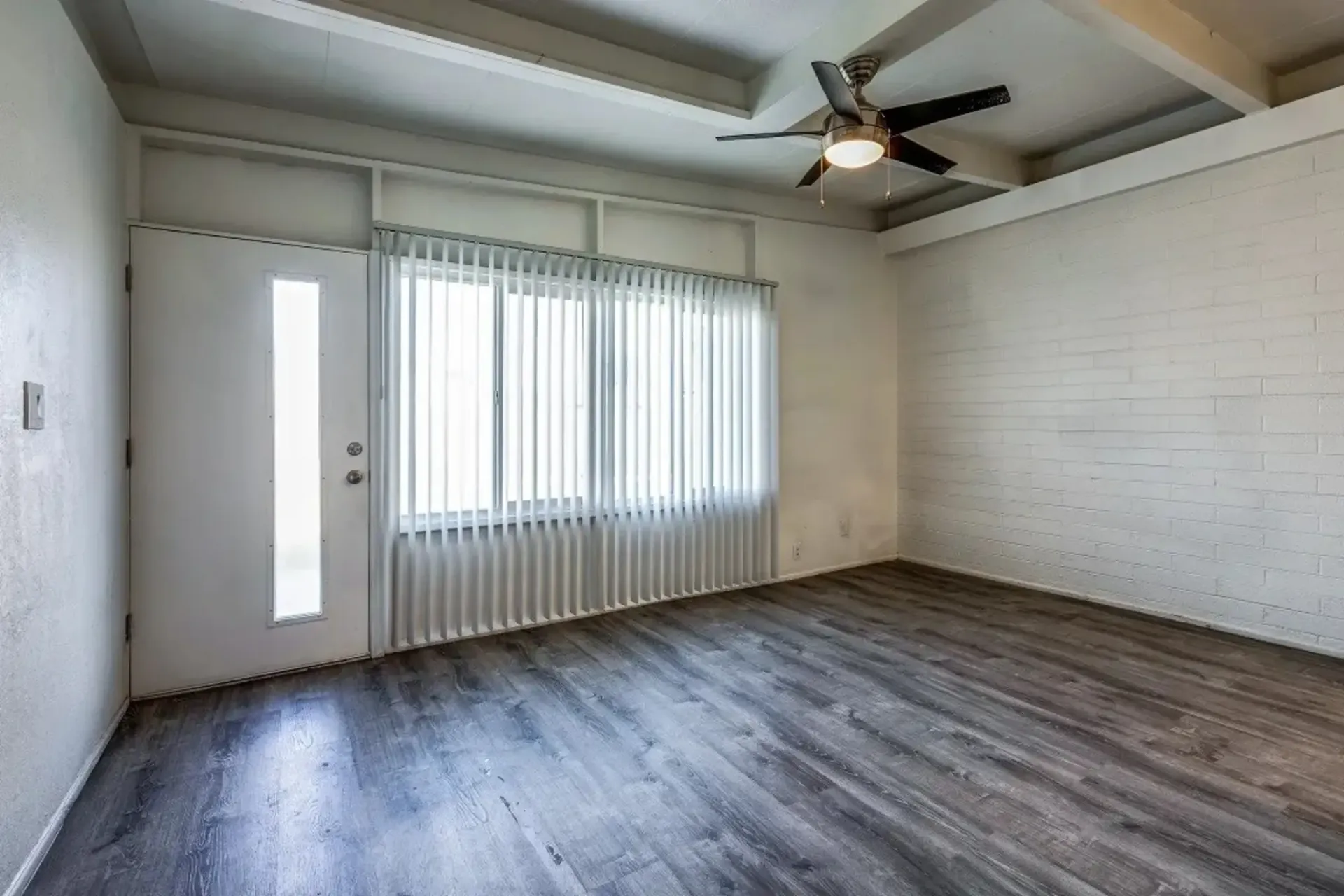 an empty room with a ceiling fan and blinds