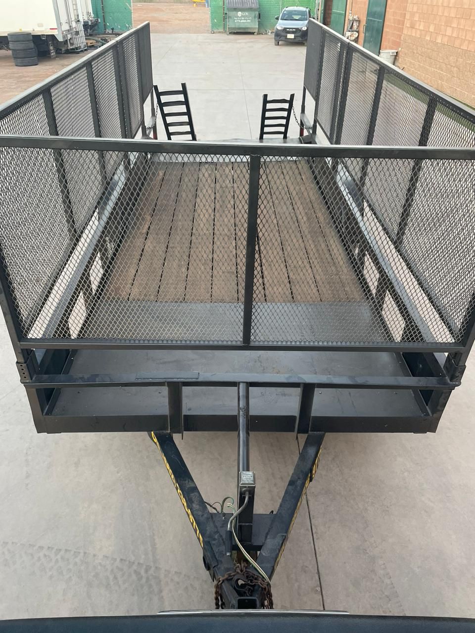 Un remolque con una escalera adjunta está estacionado en un estacionamiento.