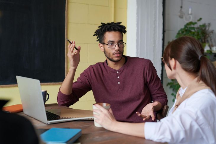 2 people talking at work during a business meeting