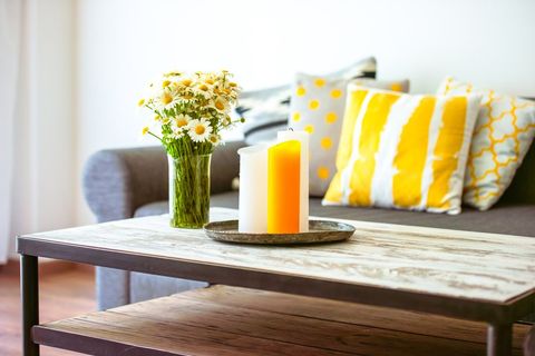 A home interior with green and yellow interior design and fresh flowers on the coffee table