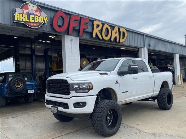 White lifted RAM truck in front of 