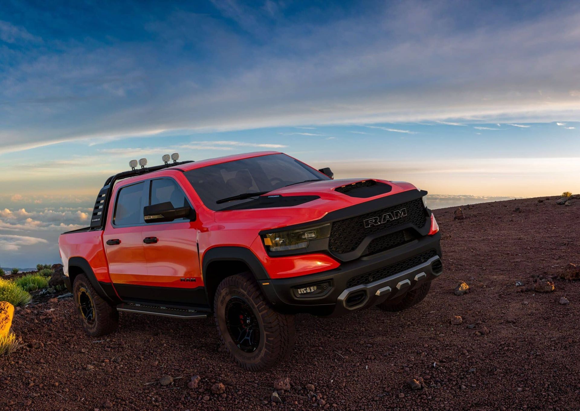 Red Ram TRX pickup truck on a rocky slope against a blue sky.