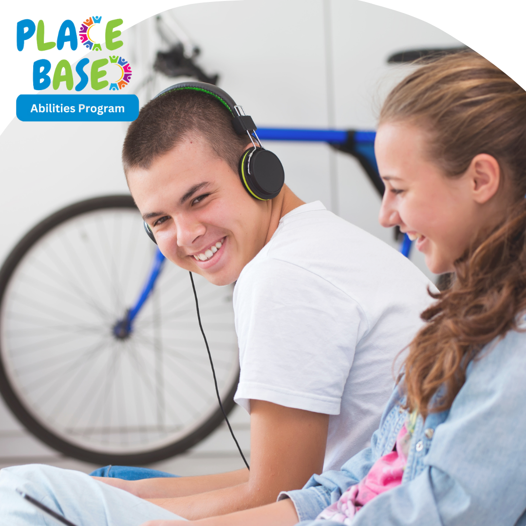 Two young people smiling and sitting next to each other