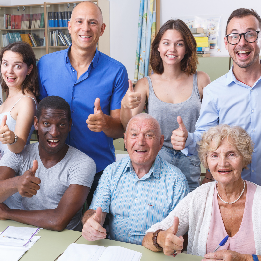 Group of men and women of all ages with smiles on their faces and their thumbs up