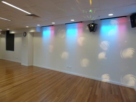 Social hall space with coloured ceiling lights on shining bright colours on the walls.