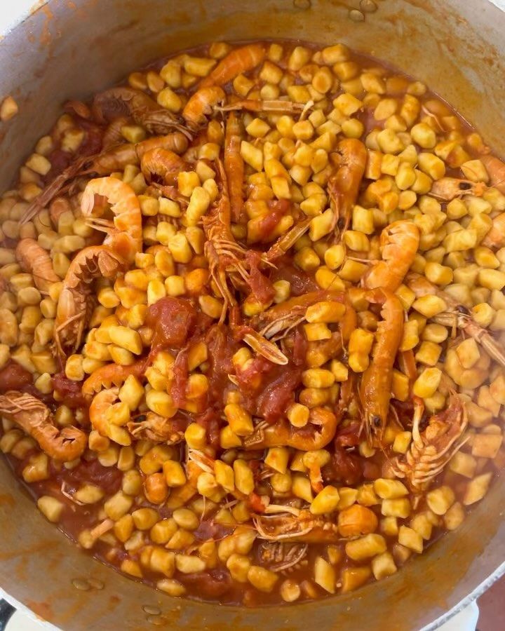 Pentola di gamberi e gnocchi in salsa di pomodoro, pronta da servire.