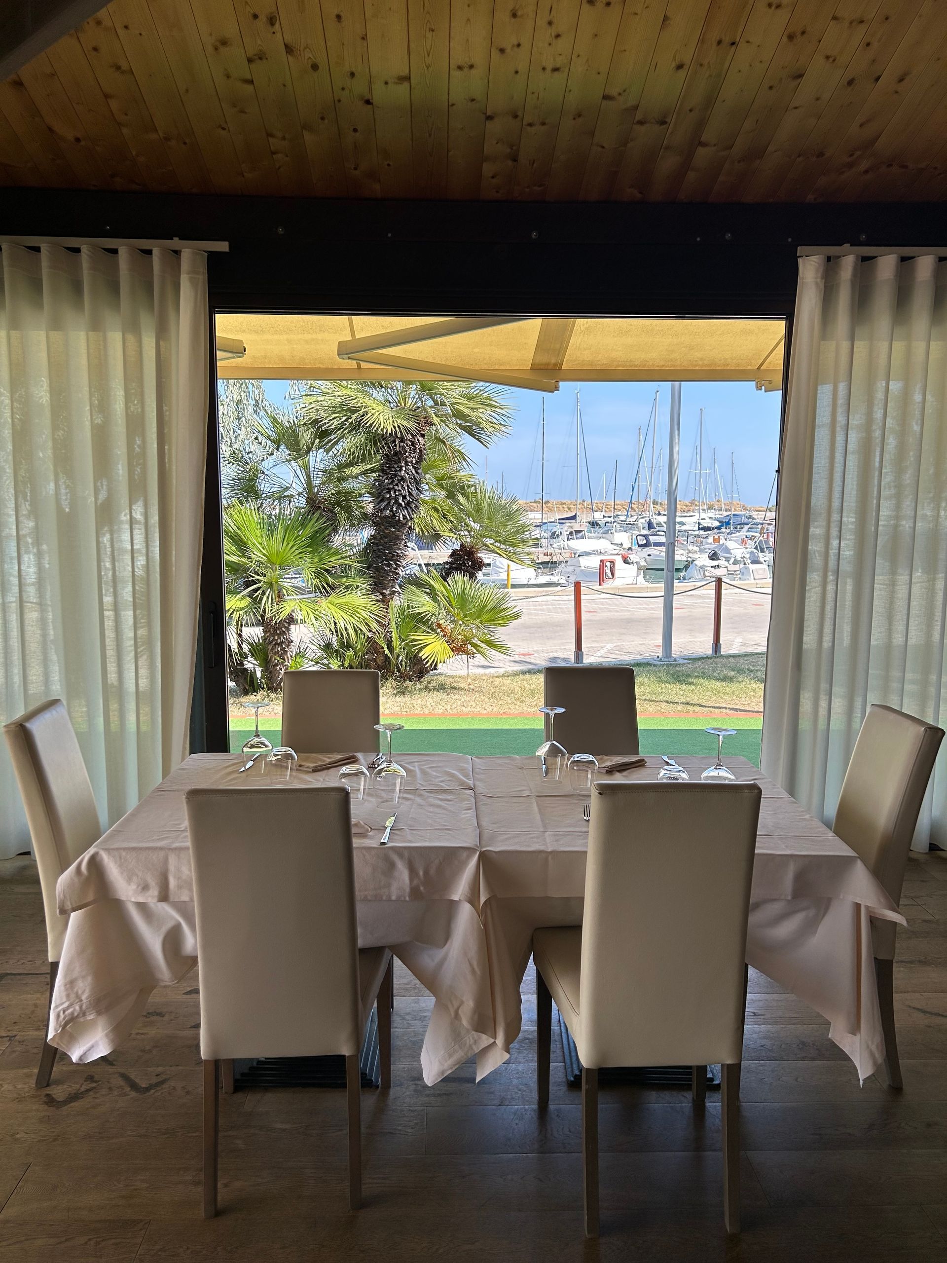 Una sala da pranzo con tavolo e sedie e vista sul porto