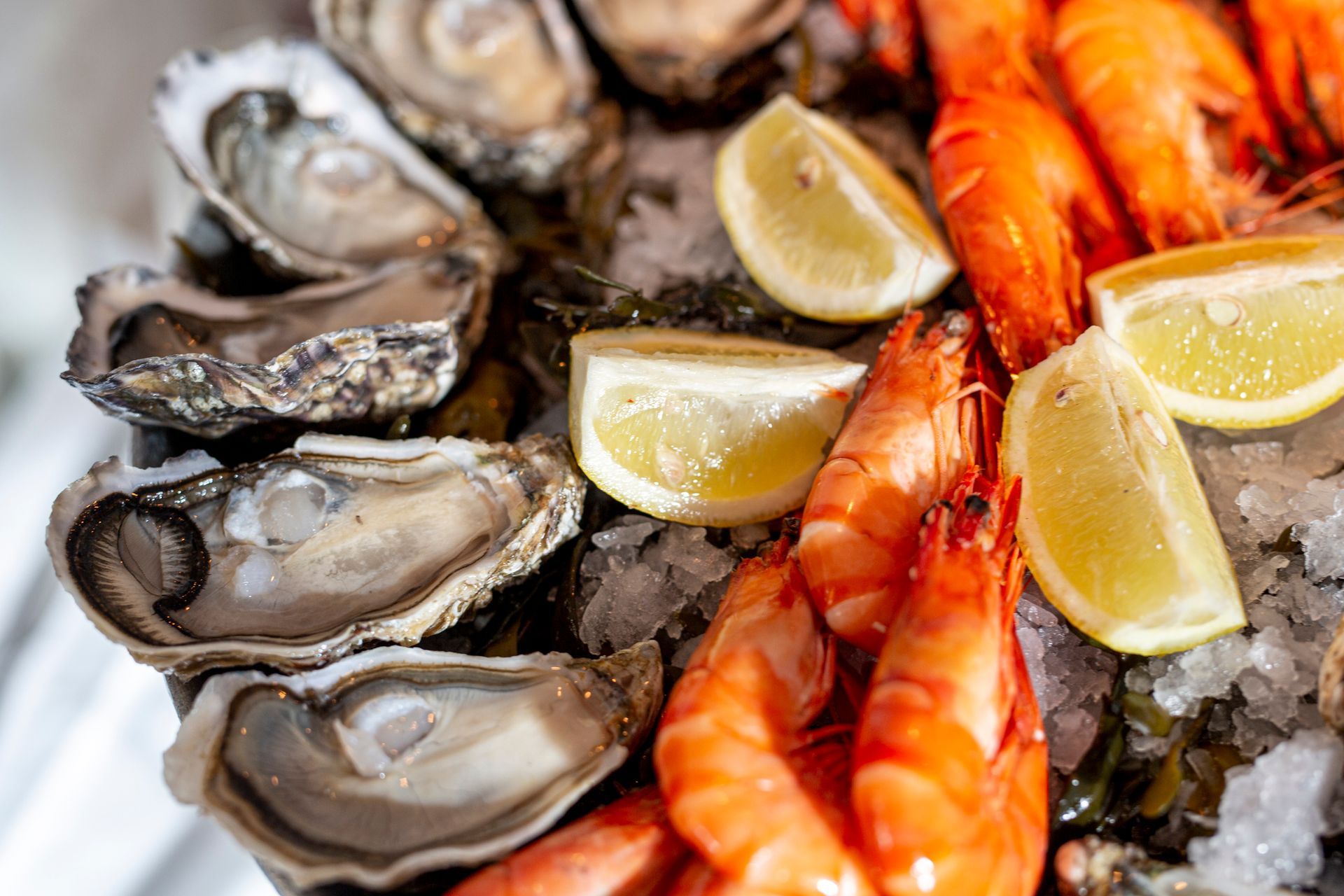 Ostriche, gamberi e spicchi di limone su ghiaccio.