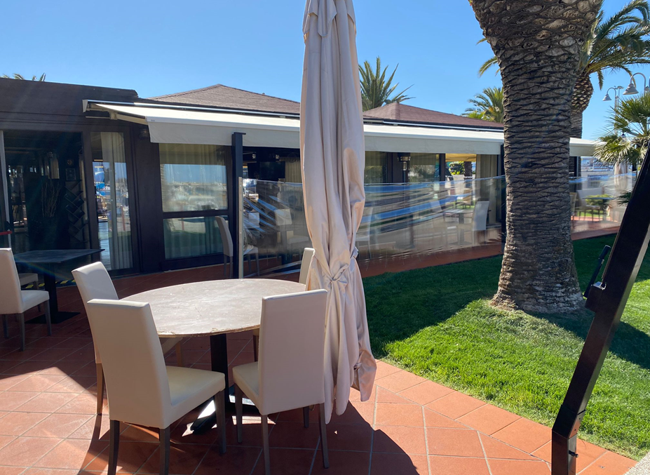 Un patio con tavolo, sedie e ombrellone