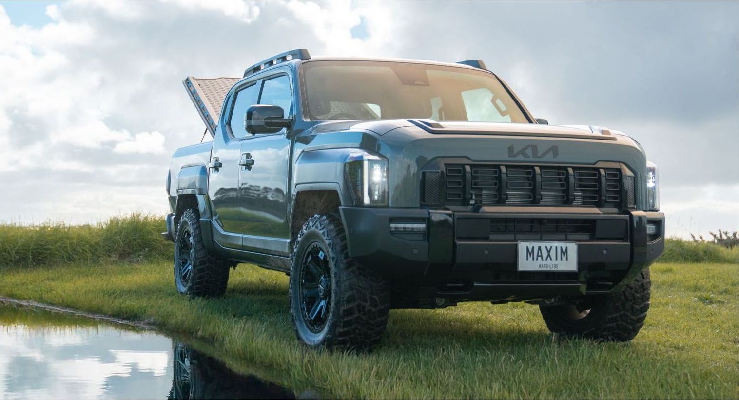 Kia Tasman with MAXIM Hard Lid and MAX tie down rails open on the water.