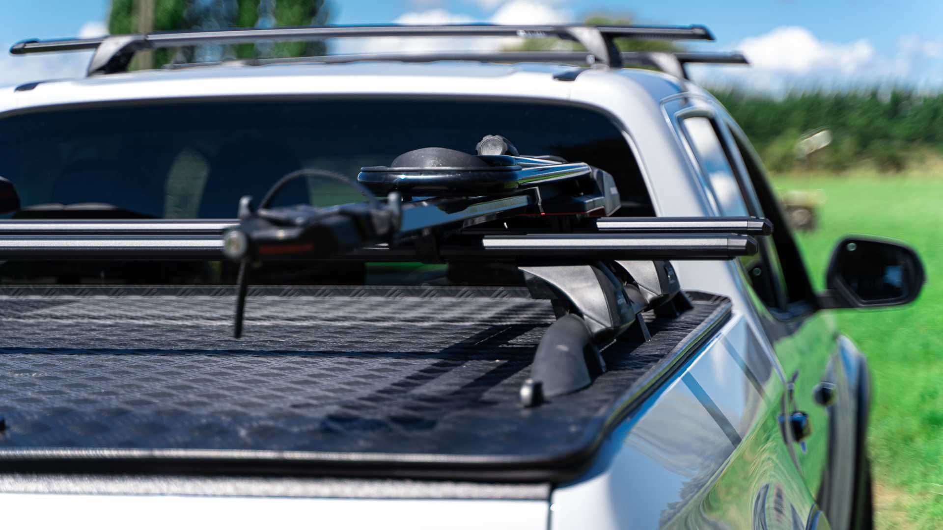 The back of a truck with a MAXIM Hard Lid. The the trunk open and a bunch of stuff in it.