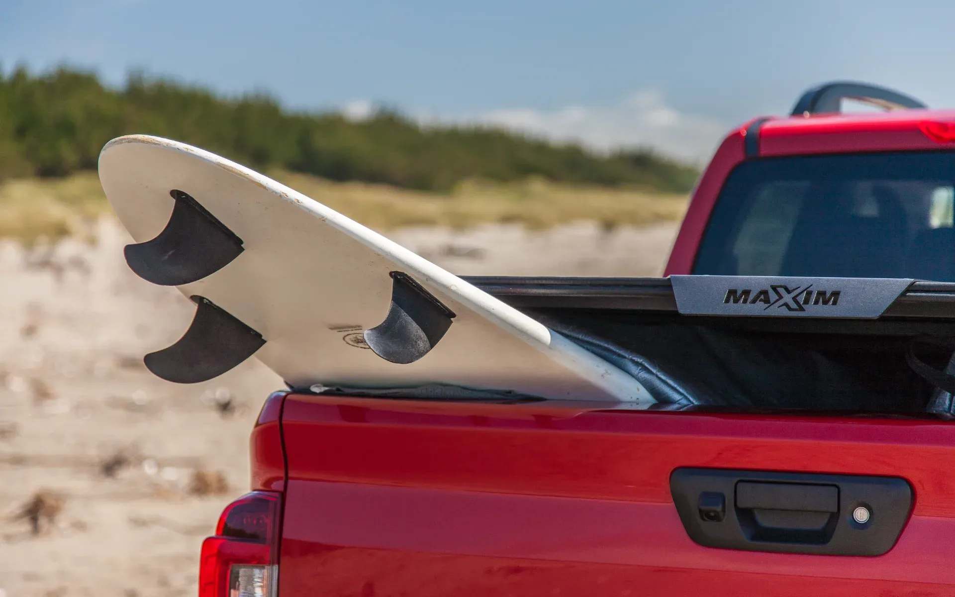 Nissan Navara with MAXIM Hard Lid on the beach with surf board.