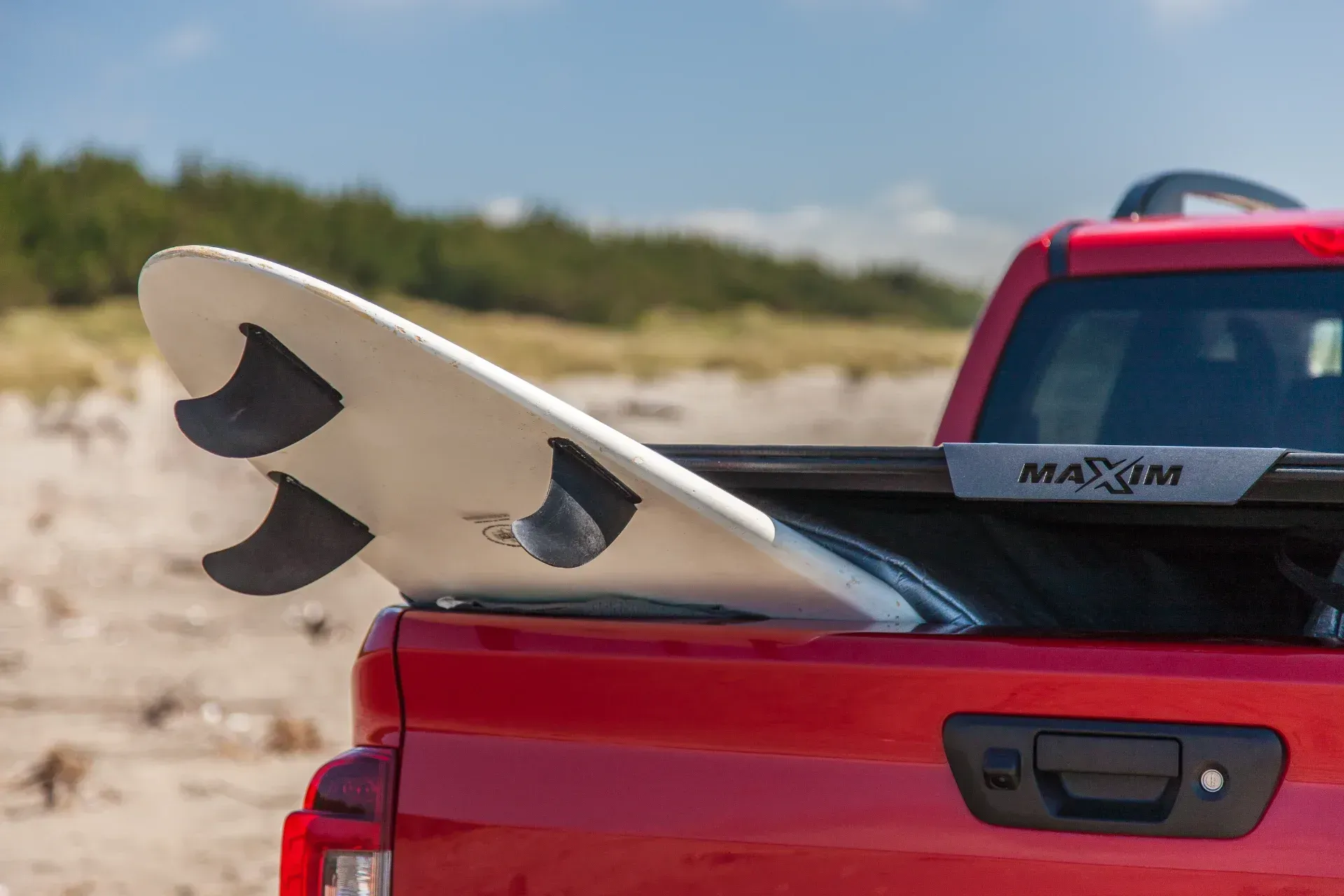 Nissan Navara with MAXIM Hard Lid on the beach with surf board.