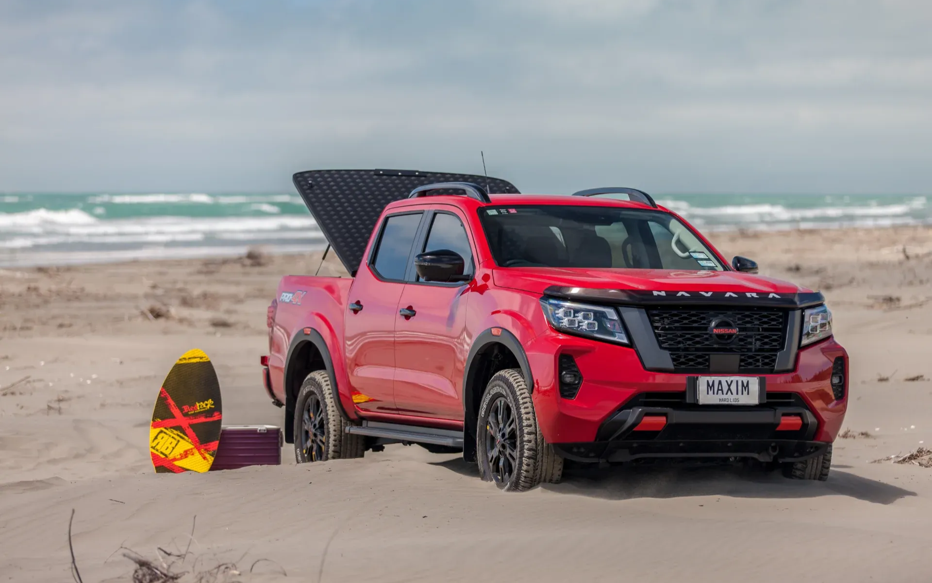 Nissan Navara with MAXIM Hard Lid on the beach with surf board.