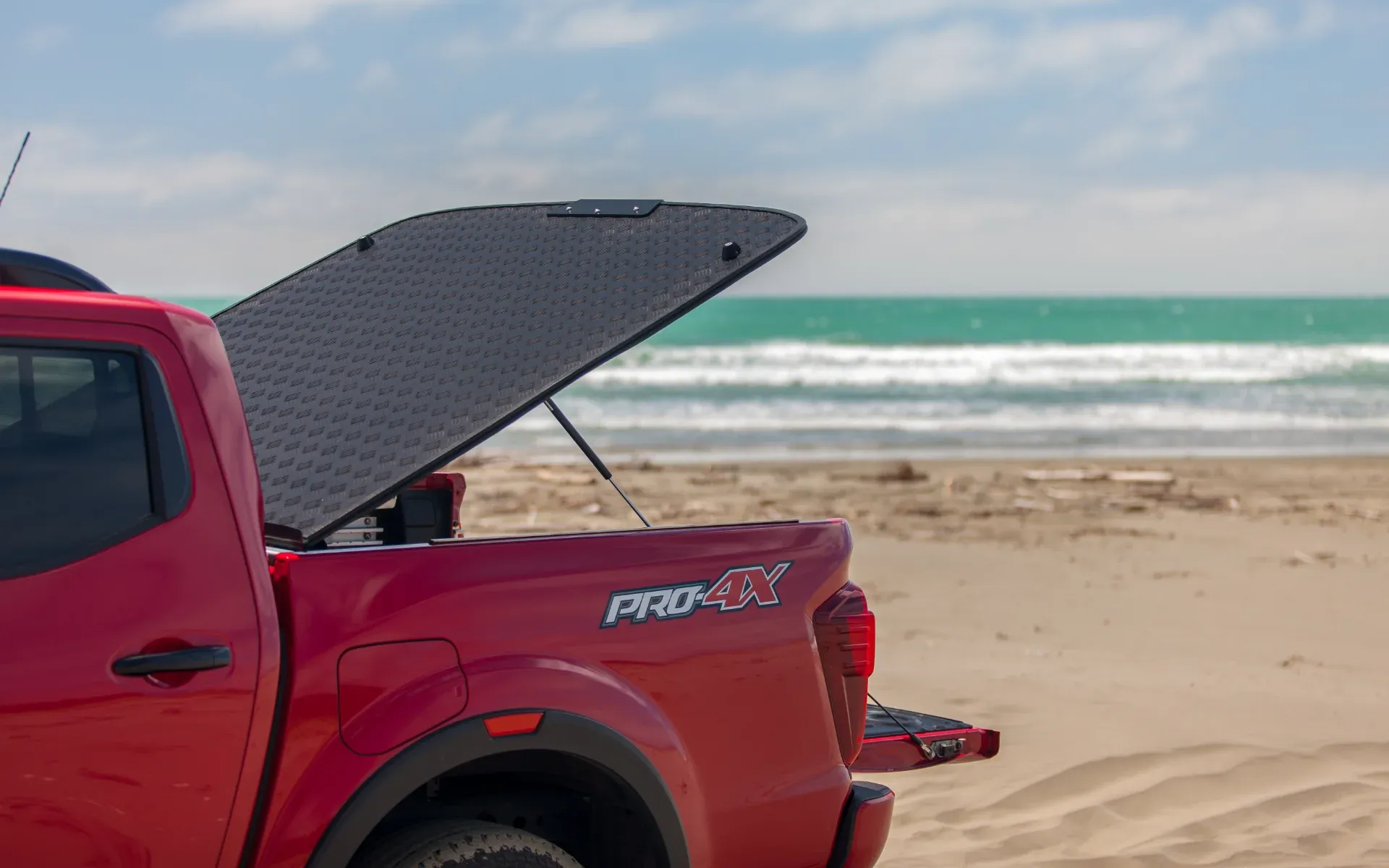 Nissan Navara with MAXIM Hard Lid on the beach with surf board.