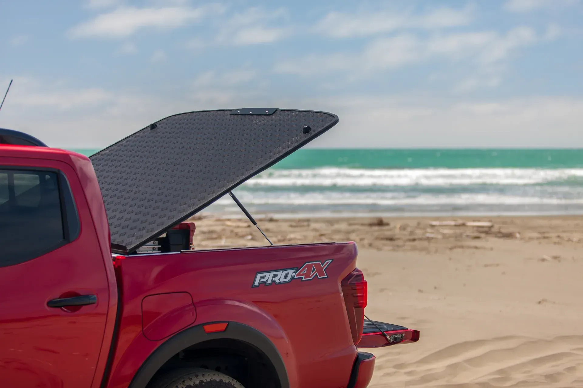 Nissan Navara with MAXIM Hard Lid on the beach with surf board.