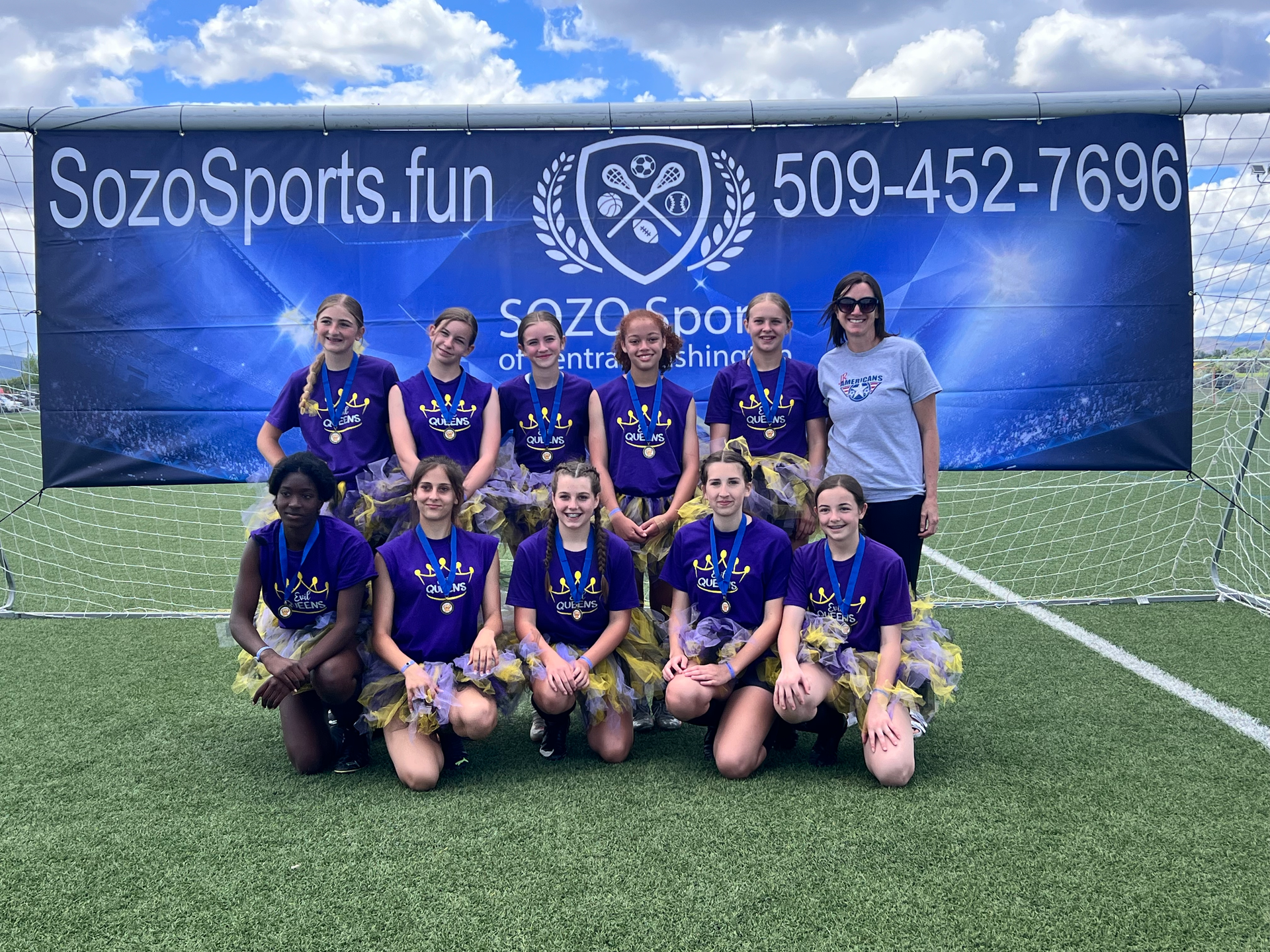 A group of girls are posing for a picture on a field.