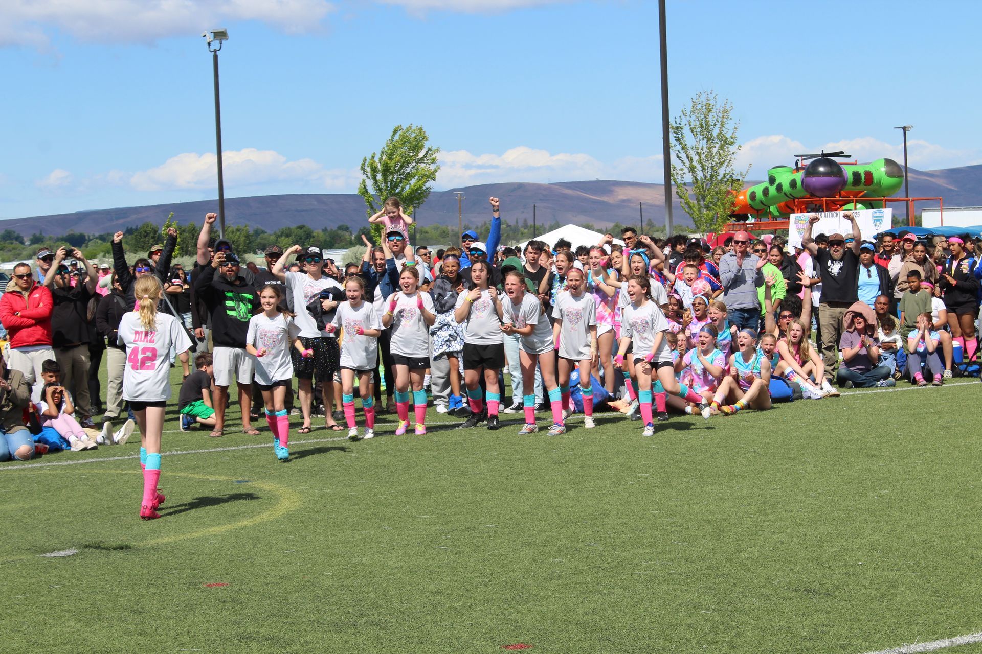 A group of people are standing on top of a soccer field.