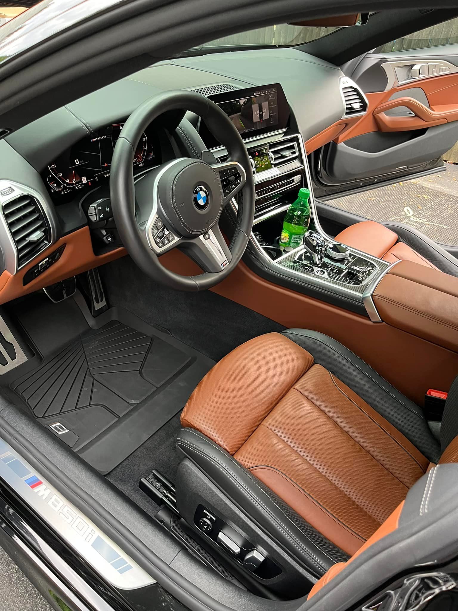 The interior of a car with brown seats and a steering wheel.
