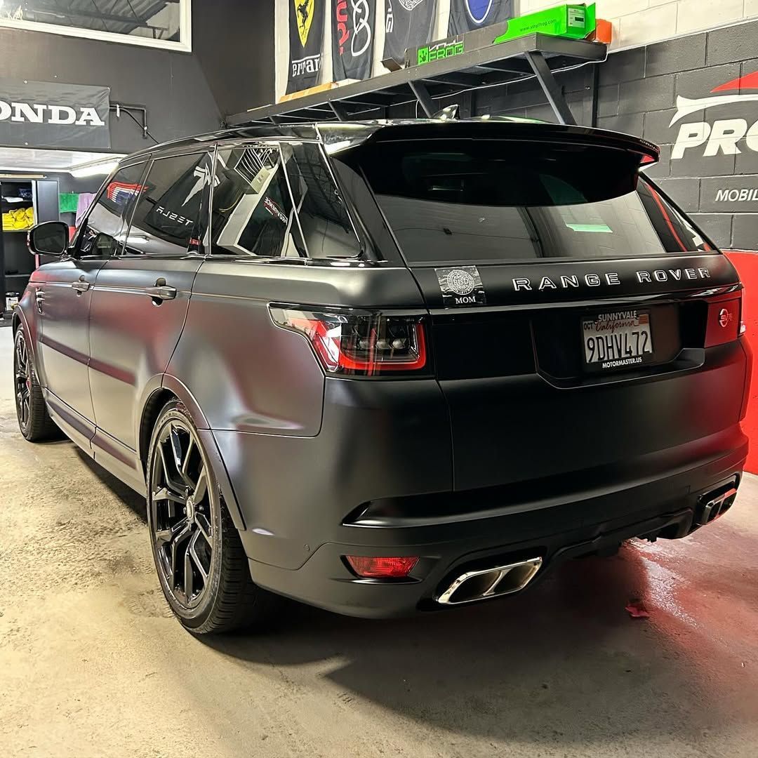 A black range rover sport is parked in a garage.