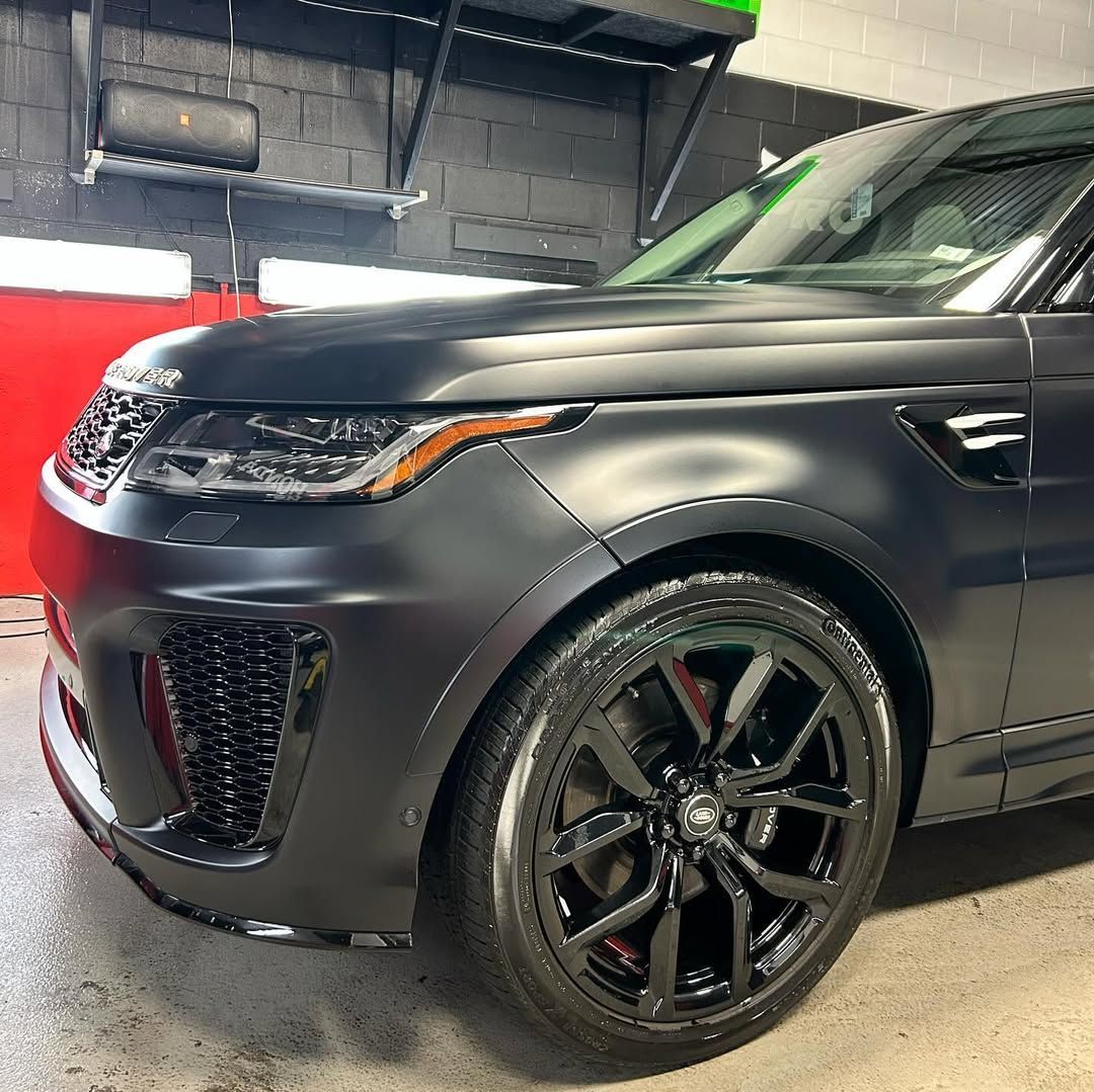 A black range rover is parked in a garage.