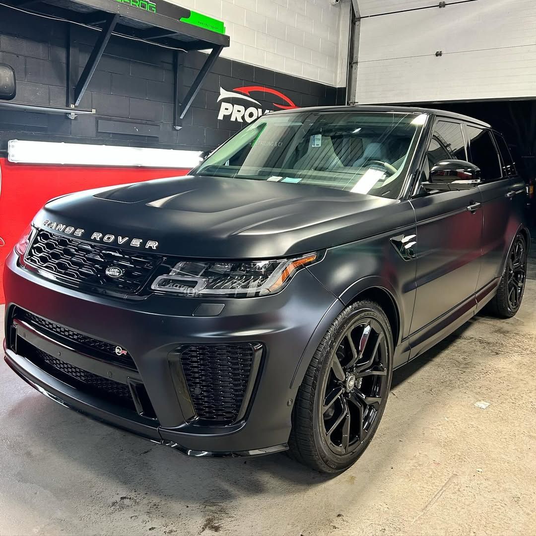 A black range rover sport is parked in a garage.