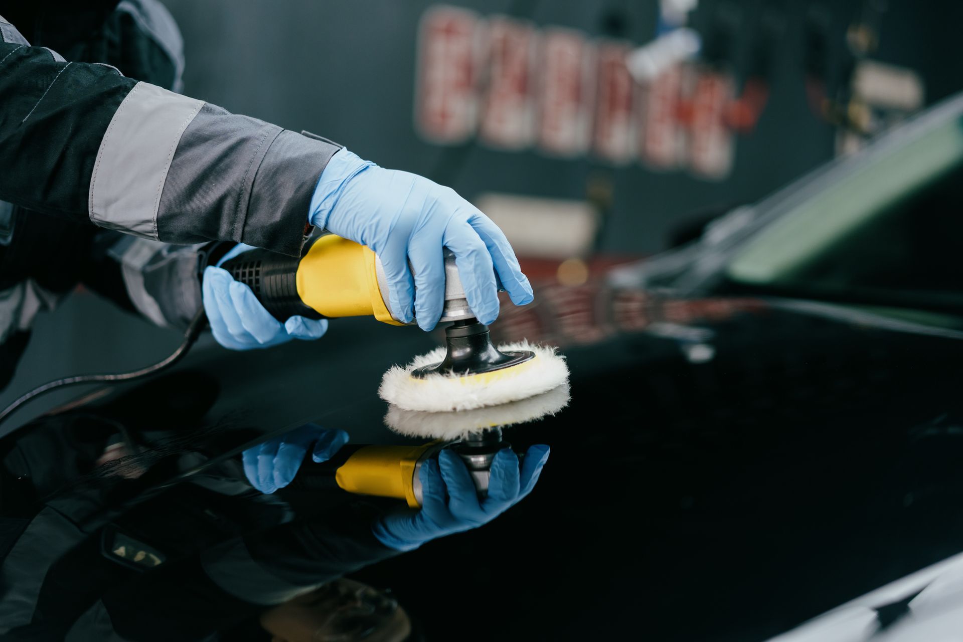 A person is polishing a car with a machine.