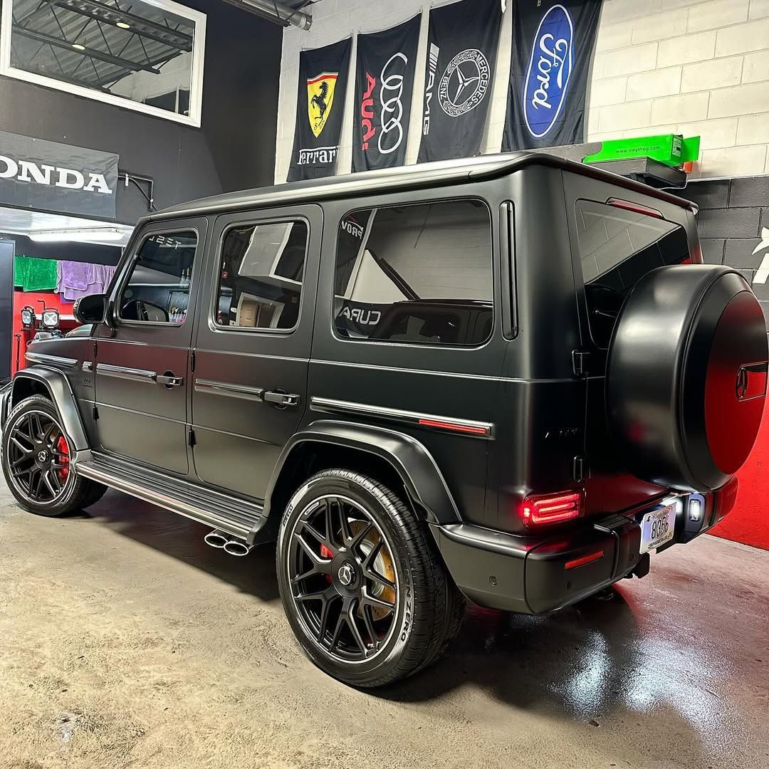 A black jeep is parked in a garage.