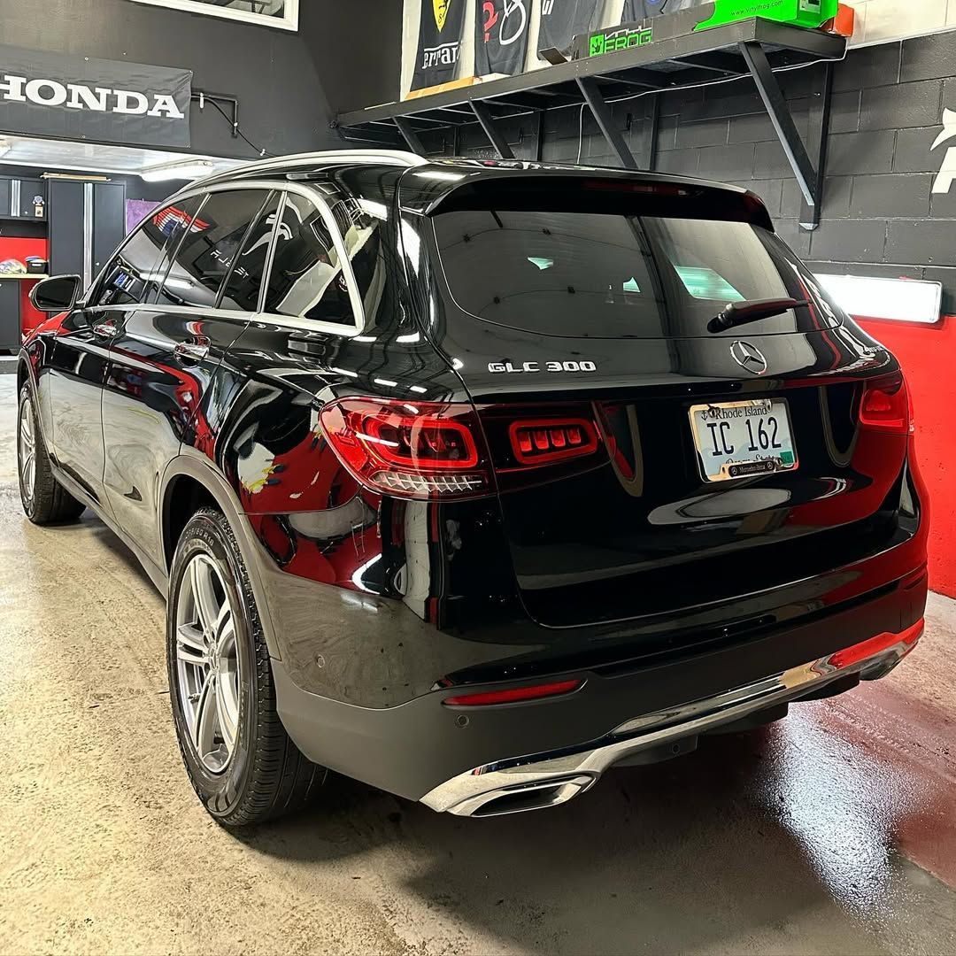 A black mercedes benz glc 300 is parked in a garage.