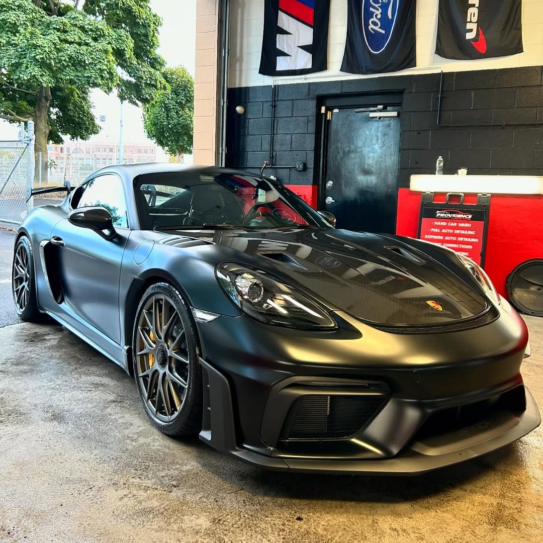 A black sports car is parked in a garage.