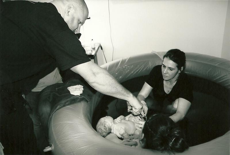 father cutting umbilical cord just after water birth - Heavenly Hands Birthing Center