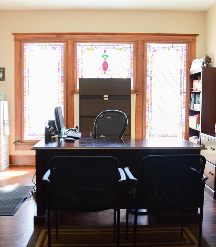A desk with two chairs and a computer on it