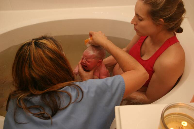 midwife washing baby after water birth - Heavenly Hands Birthing Center