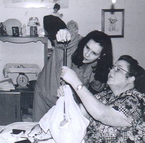 Tina weighing baby with handheld scale - Heavenly Hands Birthing Center