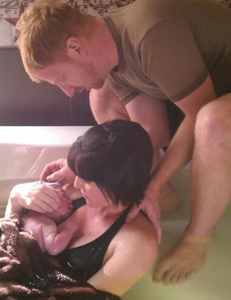 father with mother and baby just after water birth - Heavenly Hands Birthing Center