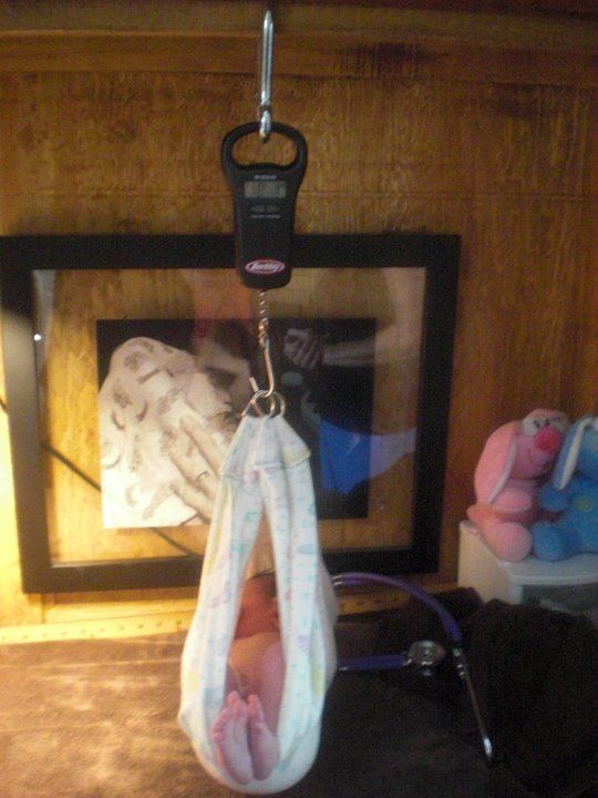 newborn baby weighed with handheld scale - Heavenly Hands Birthing Center
